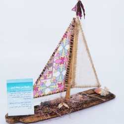 un bateaux en bois avec un voile de mer rose et balnc